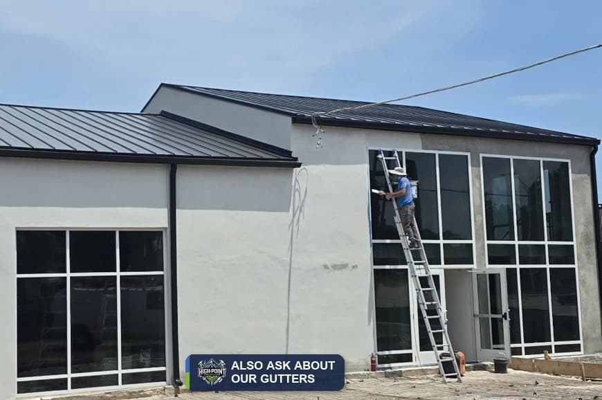 Gutter installation on a two-story home with a metal roof