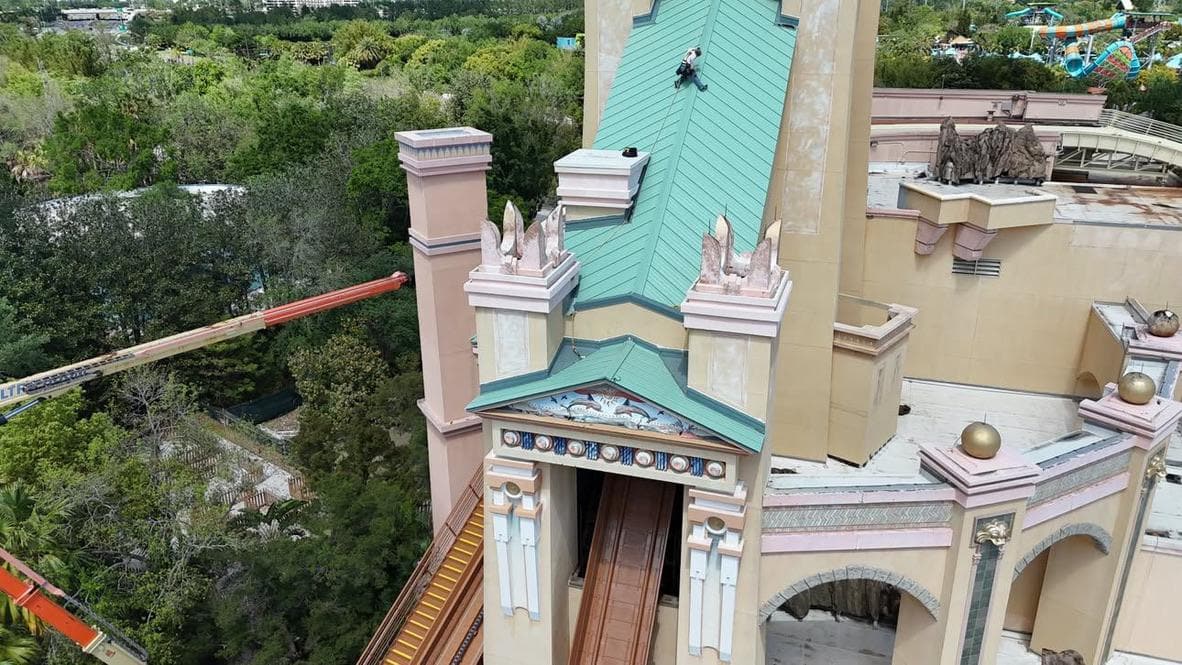 Roof work on a tall building with a turquoise roof